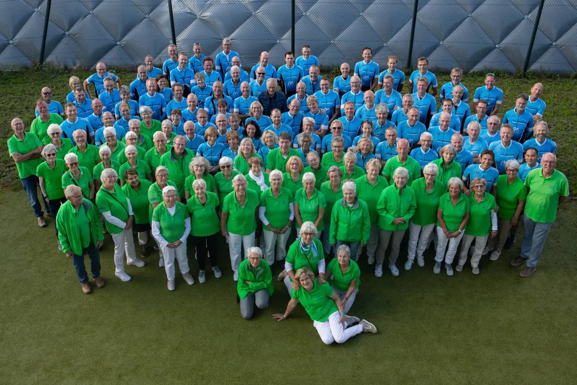 Groepsfoto van WTC Houten ’80: toerleden in het blauwe en recreanten in het groene clubtenue
